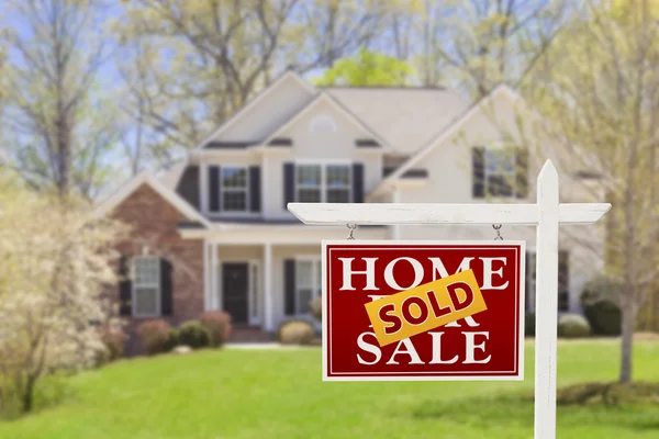 Проданный домой за знак недвижимости продаж и дом — стоковое фото
